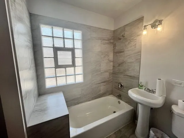 a bathroom with a sink a bathtub and window