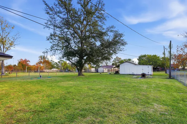 a view of a big yard with a house in the background