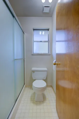 a bathroom with a toilet and a shower