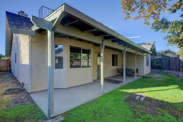 a view of a house with a yard and wooden fence
