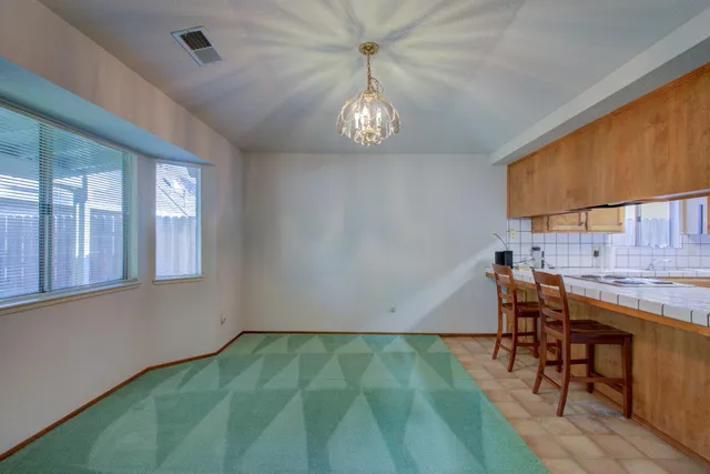 a view of a kitchen with a dining table chairs and entryway