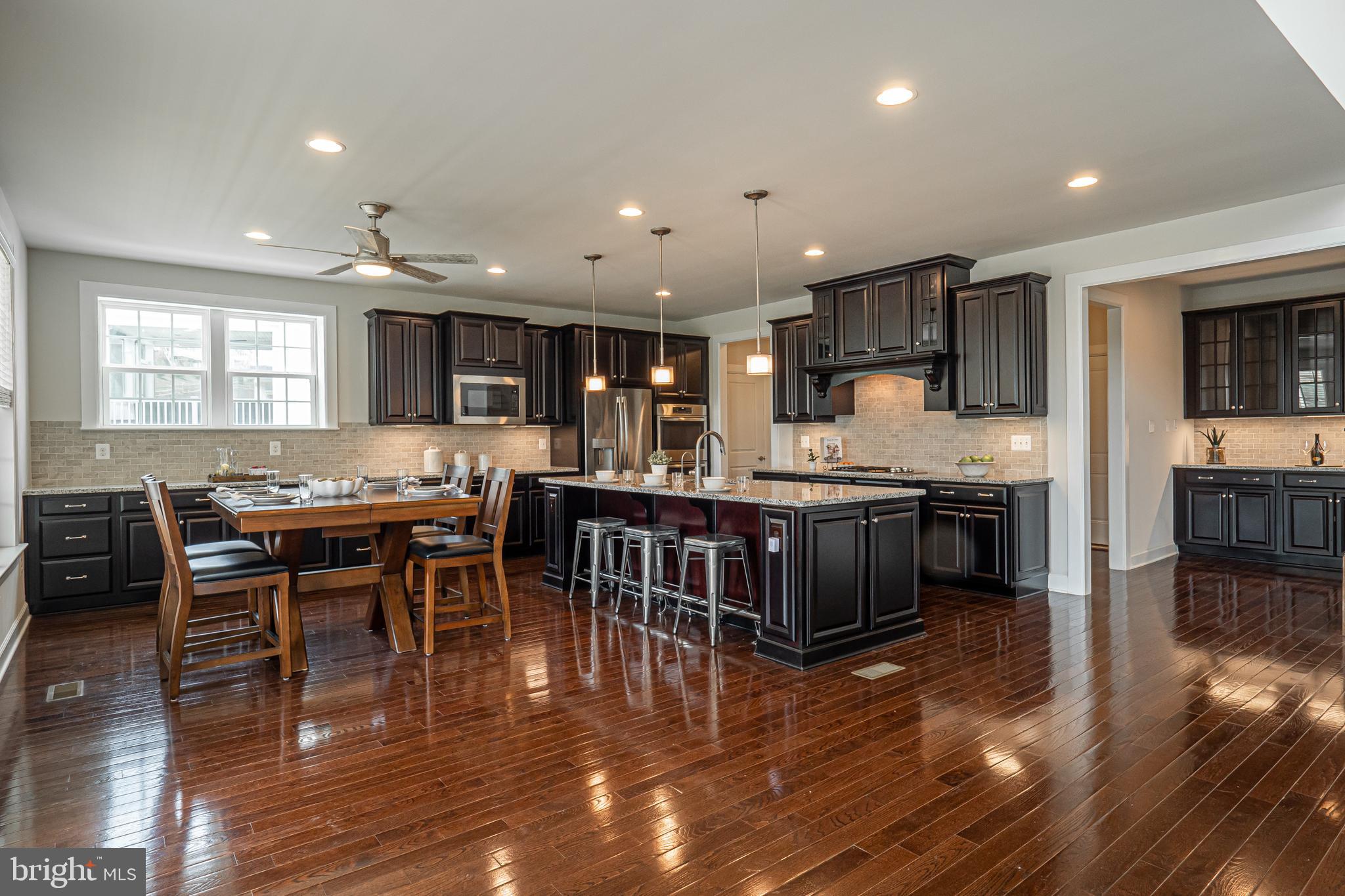 731 Stonecliffe Road Malvern, PA 19355 - Photo 23 of 81 a kitchen with stainless steel appliances kitchen island granite countertop a table chairs and a refrigerator