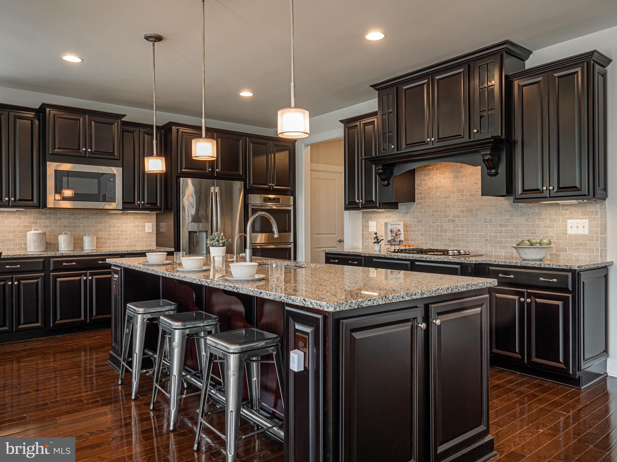 731 Stonecliffe Road Malvern, PA 19355 - Photo 26 of 81 a kitchen with stainless steel appliances granite countertop wooden cabinets a stove a sink and a microwave