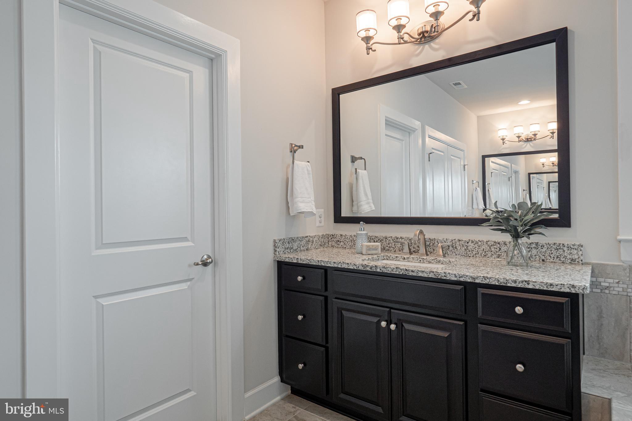 731 Stonecliffe Road Malvern, PA 19355 - Photo 51 of 81 a bathroom with a granite countertop sink vanity and mirror