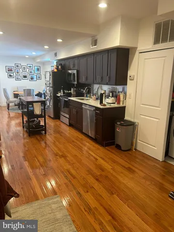 a kitchen with stainless steel appliances wooden floors and wooden cabinets