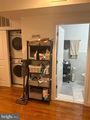 a room with a washing machine and wooden floor