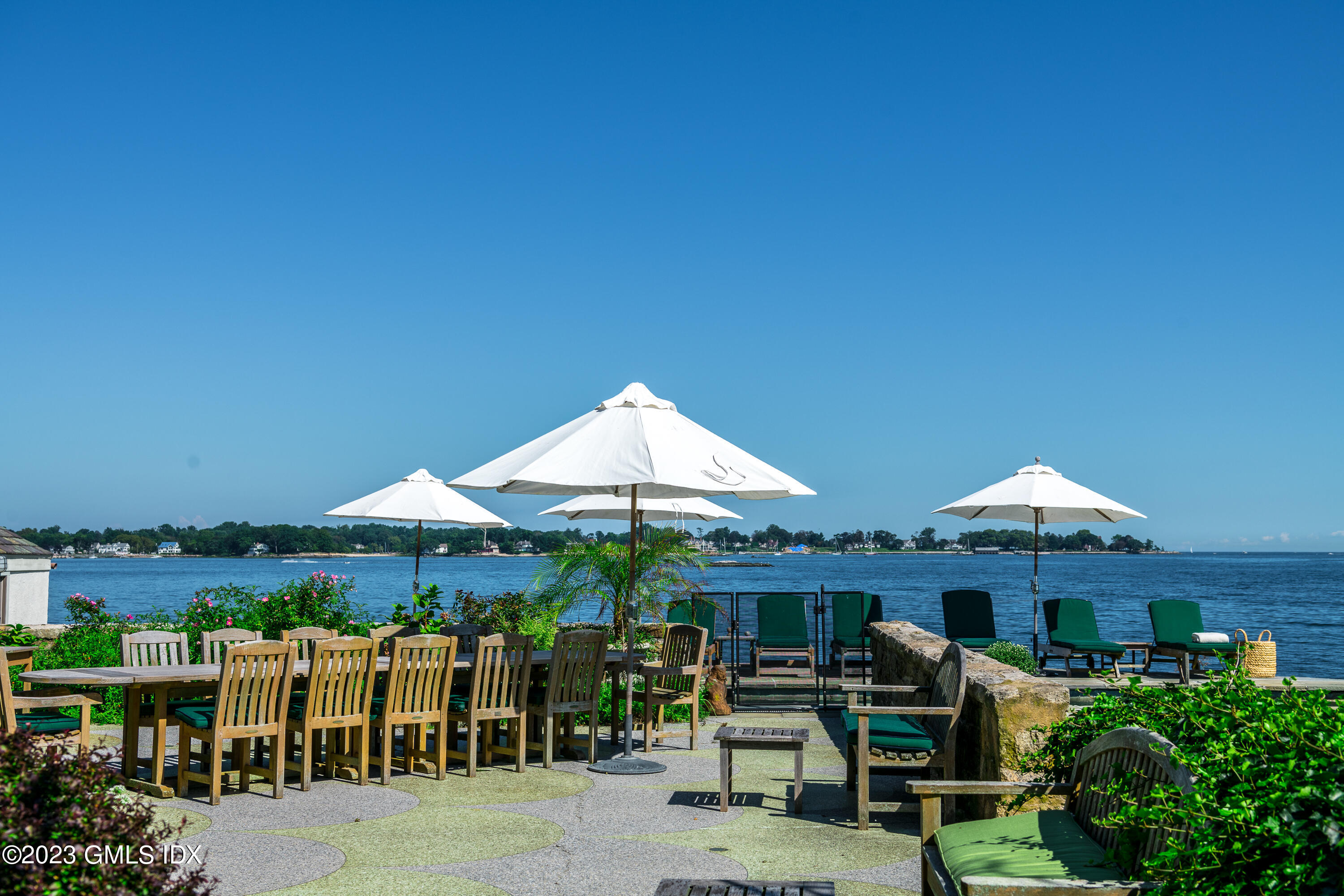 140 Wallacks Drive Stamford, CT 06902 - Photo 18 of 26 a couple of tables and chairs under an umbrella in front of house