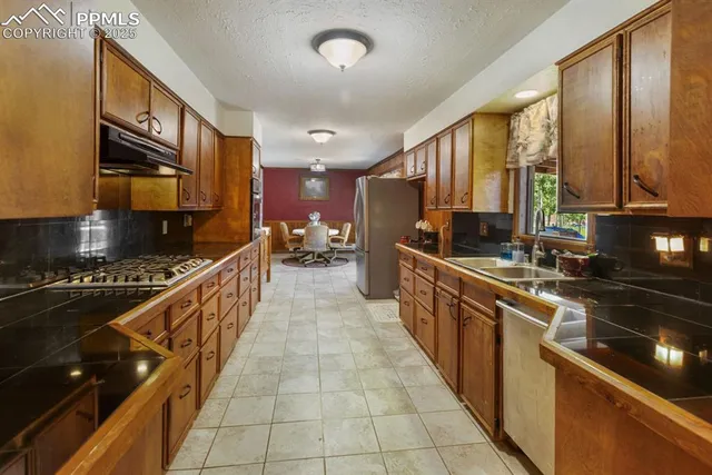 a large kitchen with stainless steel appliances a refrigerator and a stove