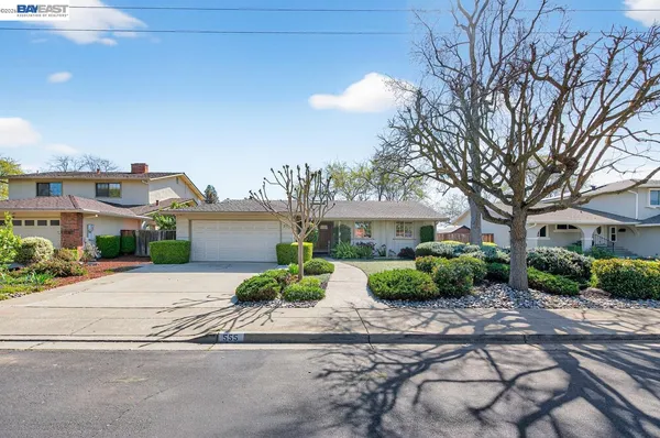 a front view of a house with a yard and potted plants