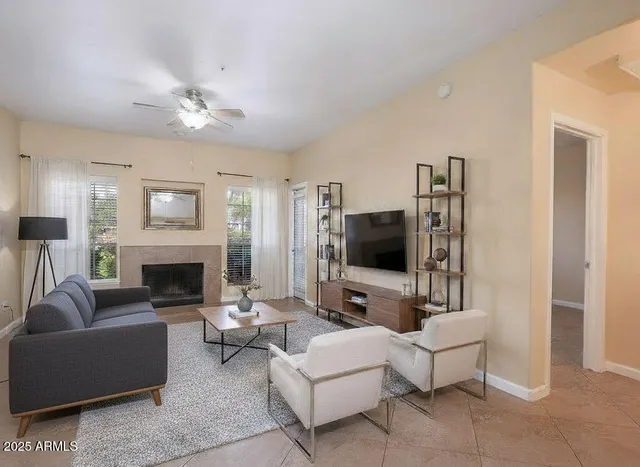 a living room with furniture a fireplace and a flat screen tv