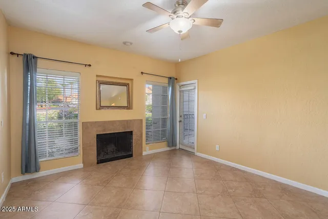 a view of an empty room with a fireplace and a window