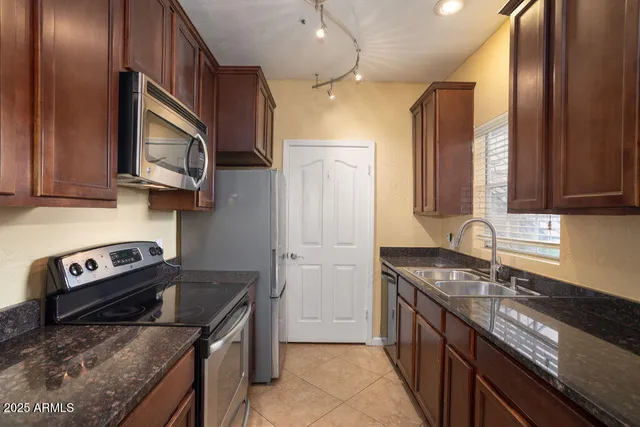 a kitchen with stainless steel appliances granite countertop a stove a sink and a microwave