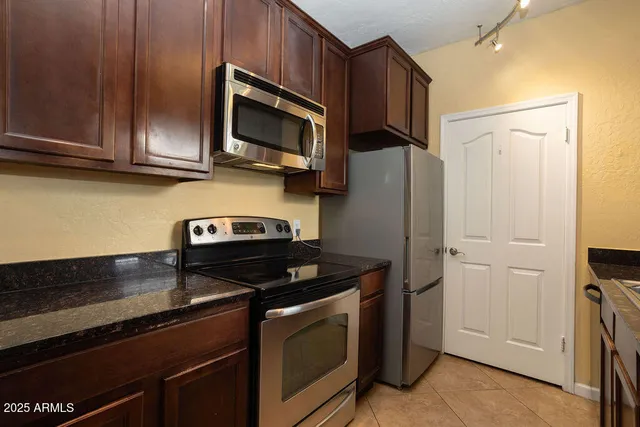 a kitchen with stainless steel appliances granite countertop a refrigerator stove and microwave