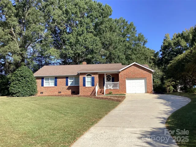 a front view of a house with a yard and trees