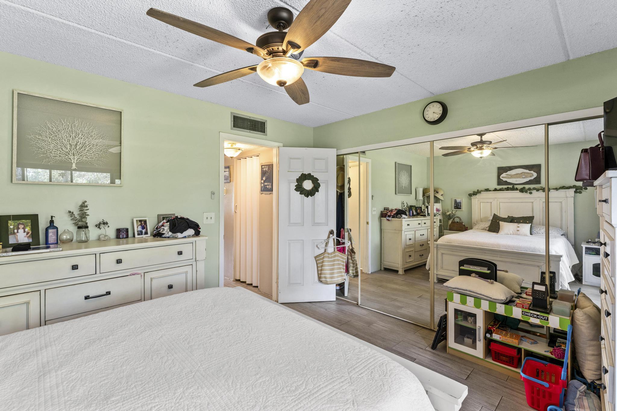 2000 Springdale Boulevard, Unit 209 Palm Springs, FL 33461 - Photo 14 of 26 a bedroom with a bed and a chandelier