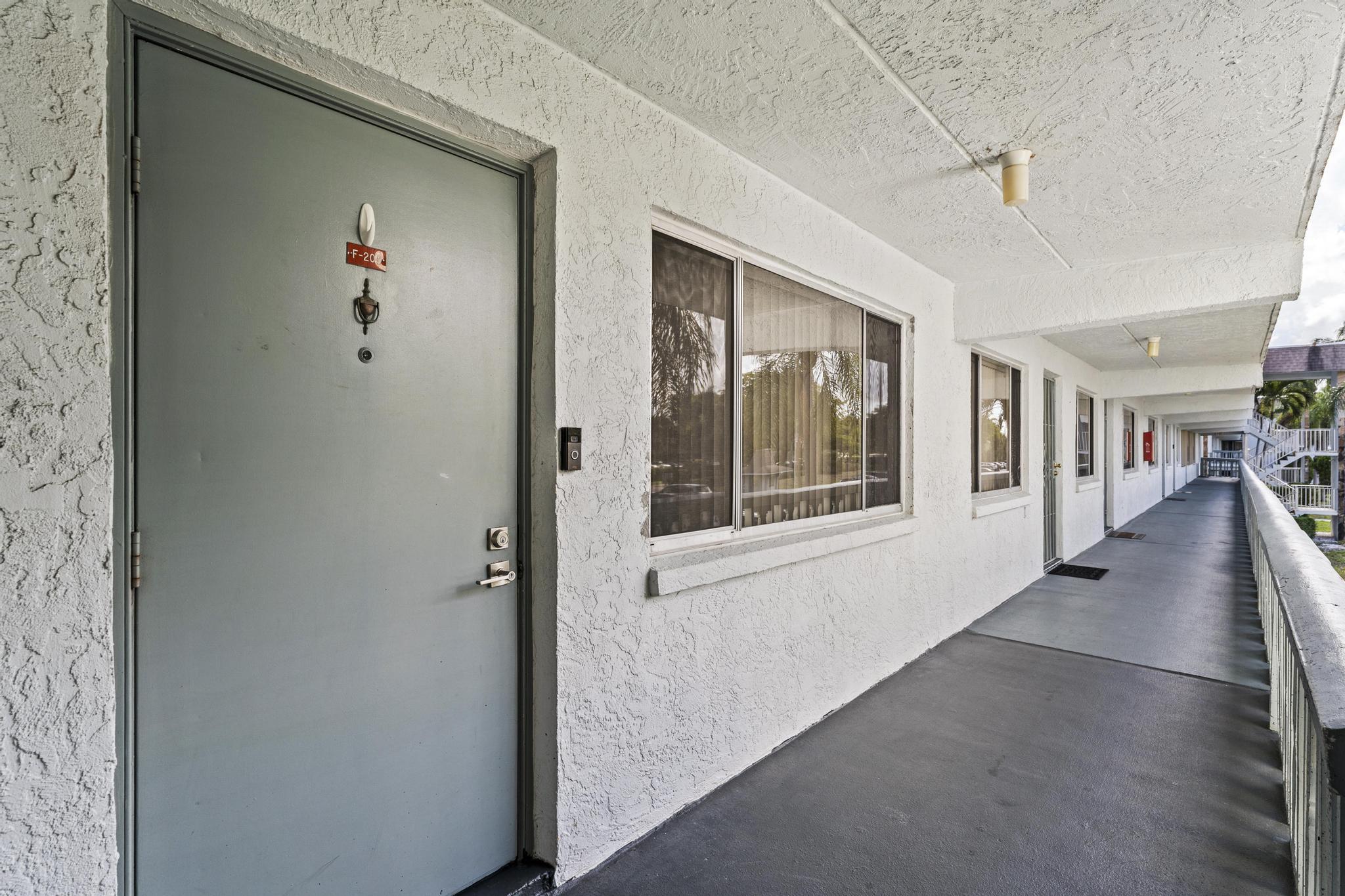 2000 Springdale Boulevard, Unit 209 Palm Springs, FL 33461 - Photo 2 of 26 a view of a hallway with paintings on the walls