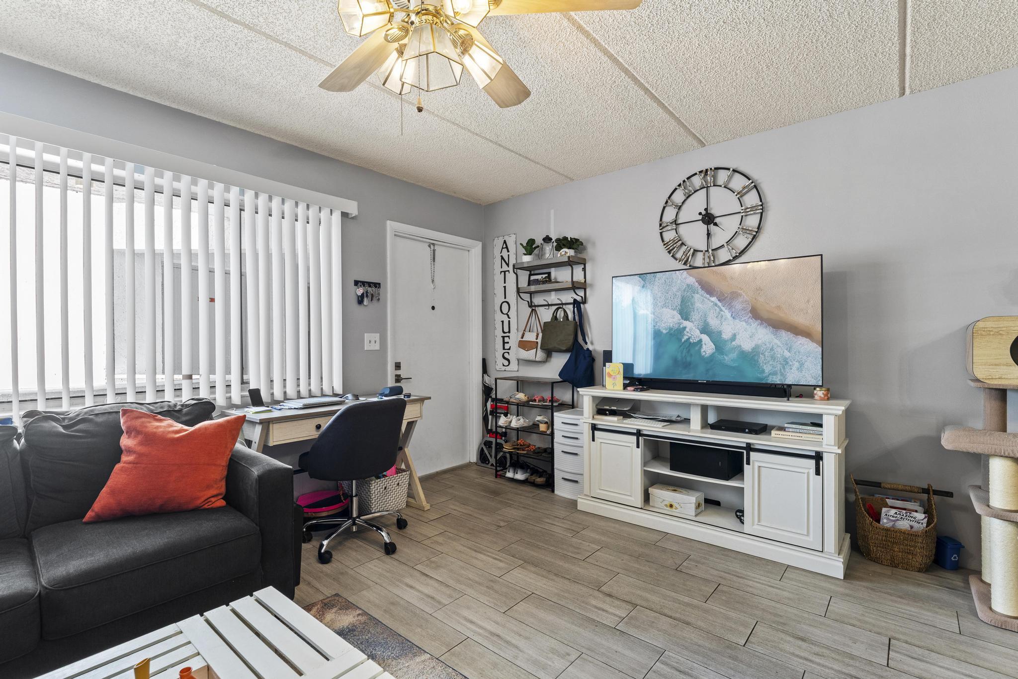 2000 Springdale Boulevard, Unit 209 Palm Springs, FL 33461 - Photo 6 of 26 a living room with furniture a flat screen tv and a fireplace