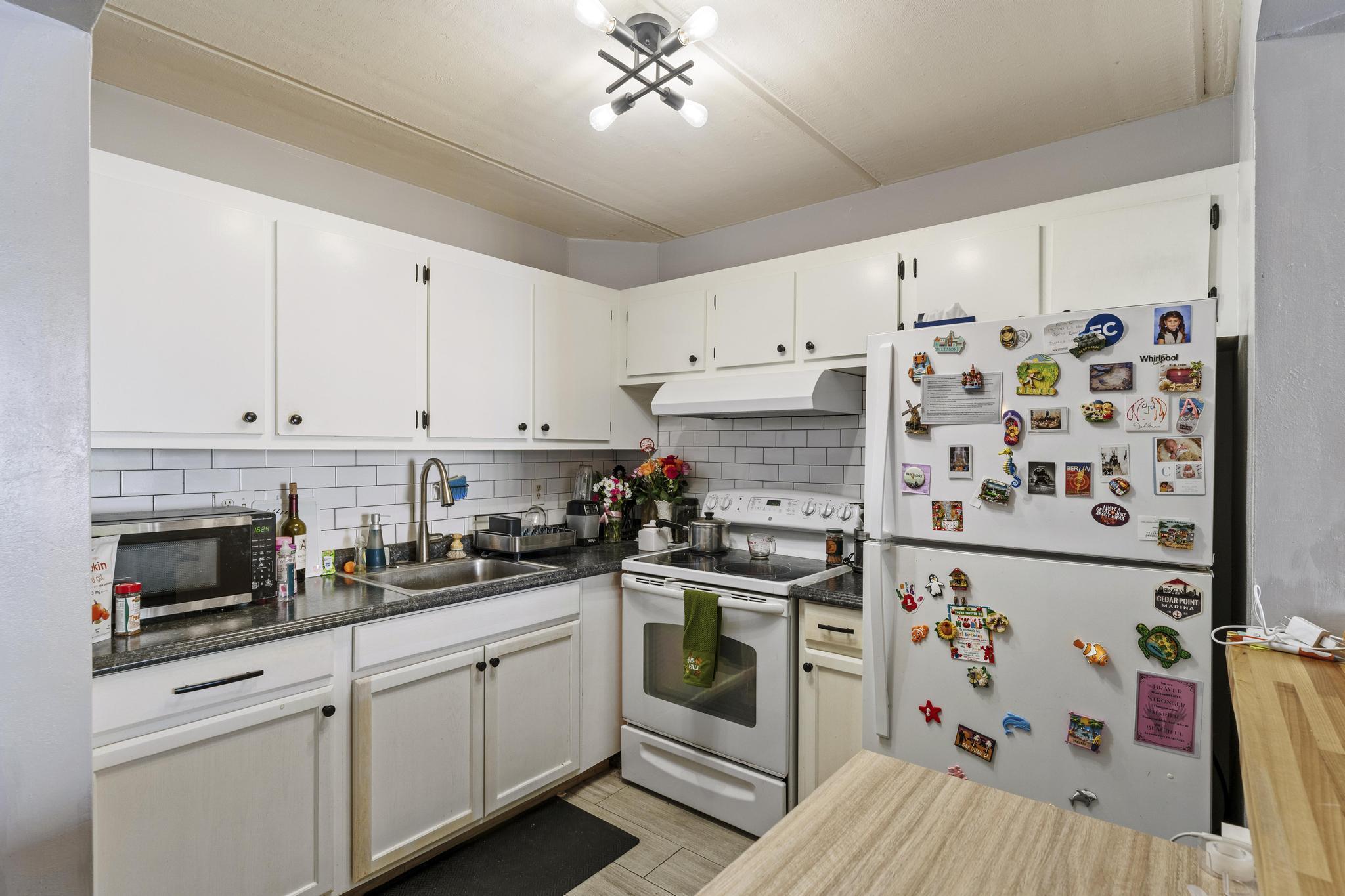 2000 Springdale Boulevard, Unit 209 Palm Springs, FL 33461 - Photo 8 of 26 a kitchen with stainless steel appliances and white cabinets