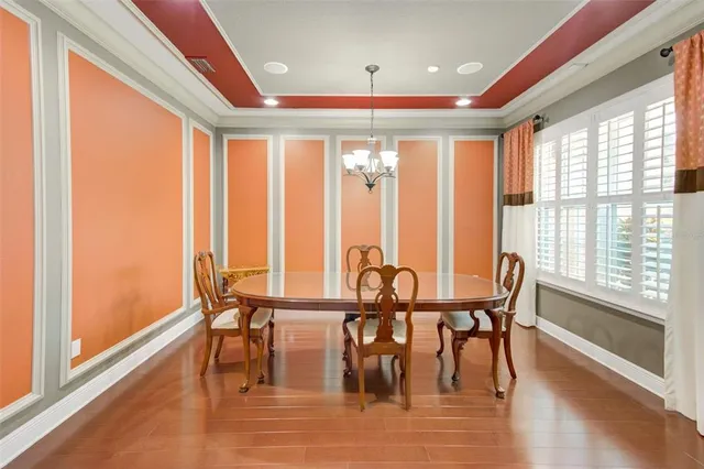 a view of a a dining room with furniture window and wooden floor