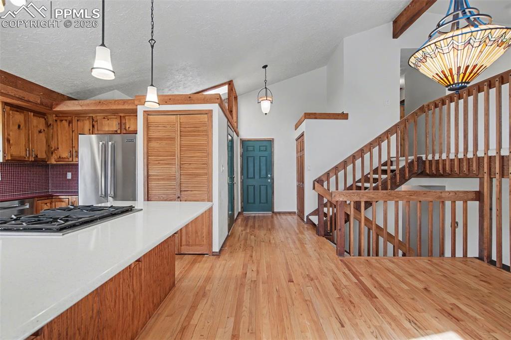 5301 Pinon Valley Road Colorado Springs, CO 80919 - Photo 12 of 27 a view of hallway with wooden floor and chandelier