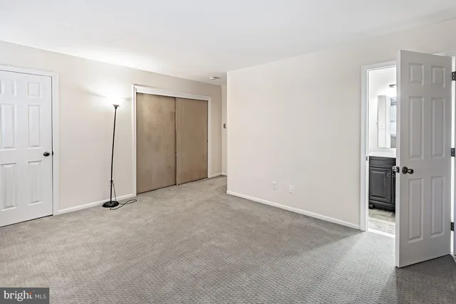 an empty room with closet and a bathroom