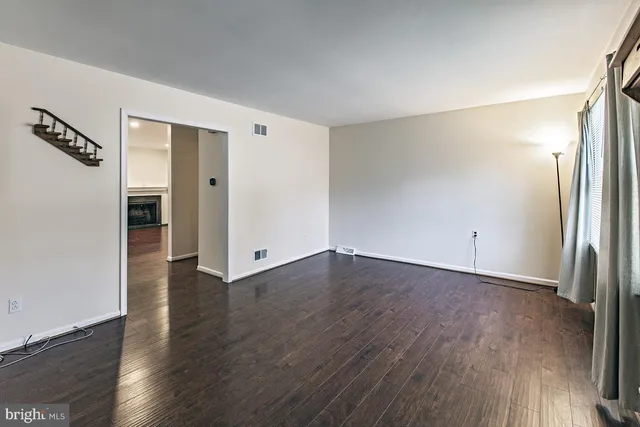 an empty room with wooden floor and a window