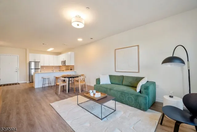 a living room with furniture and a dining table with wooden floor