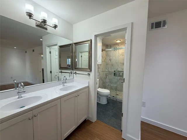 a bathroom with a sink a toilet and shower