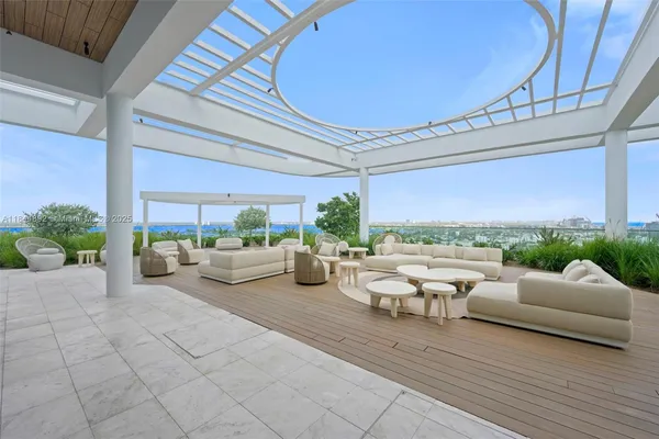 a living room with patio furniture and a floor to ceiling window