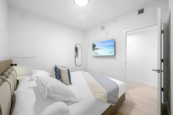 a bedroom with a bed and a painting on the wall