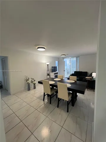 a living room with furniture a dining table and a potted plant