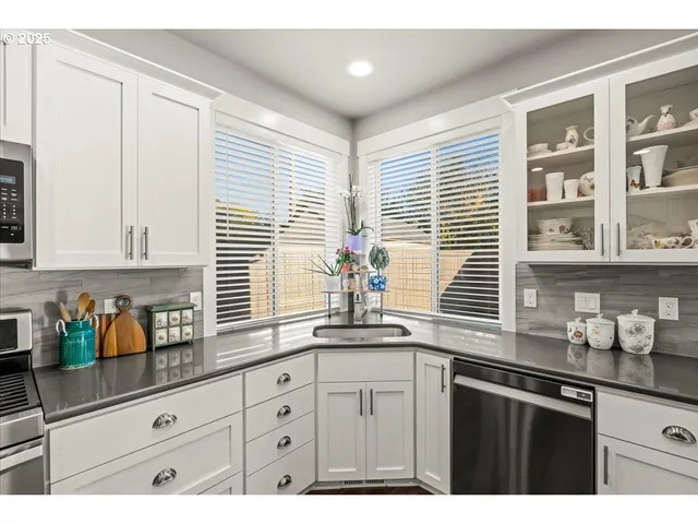 a kitchen with stainless steel appliances white cabinets and a window