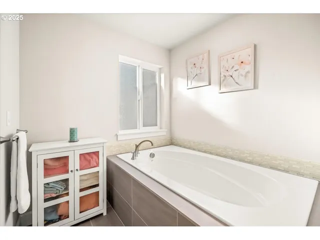 a bathroom with a tub sink and mirror