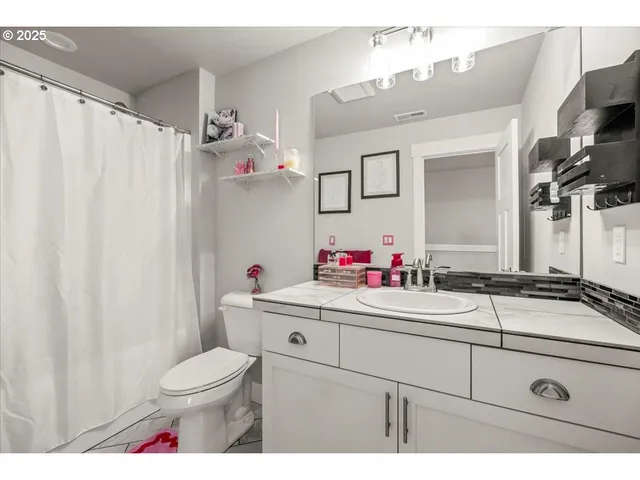 a bathroom with a sink vanity mirror and toilet