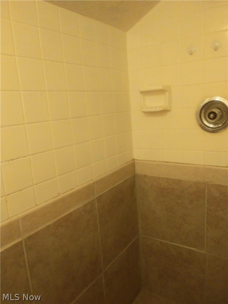 6201 Manchester Road Parma, OH 44129 - Photo 14 of 19 Tiled walk-in shower includes shelving.