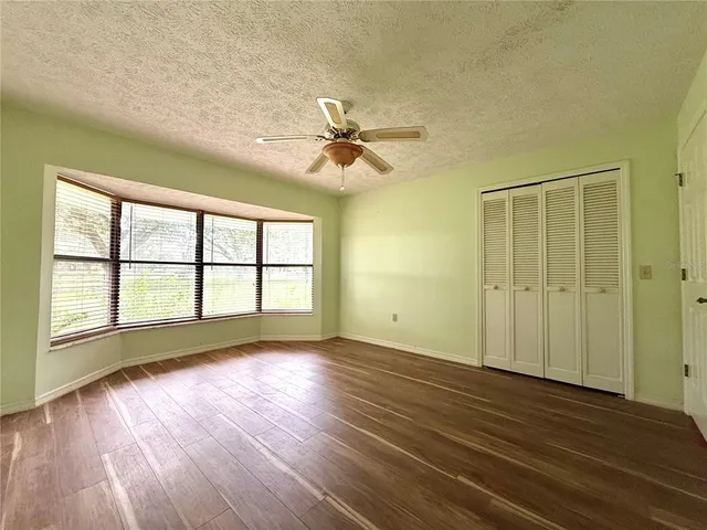 a bathroom with a granite countertop bathtub shower sink mirror vanity and toilet