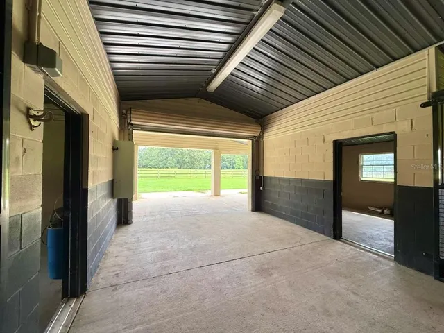 a view of a house with a big yard plants and large trees