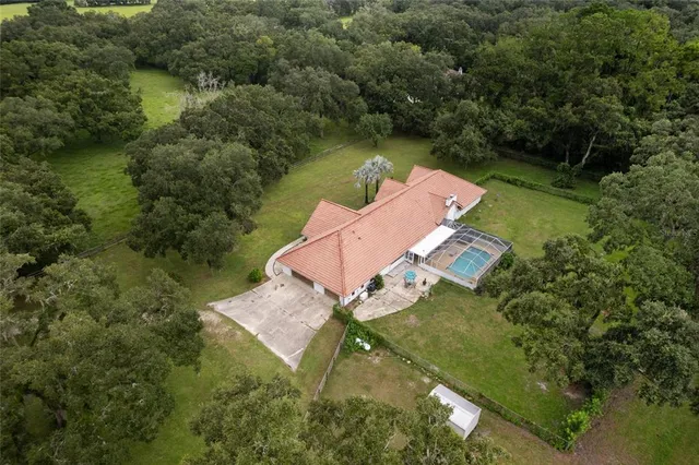 an aerial view of a house with outdoor space and a lake view