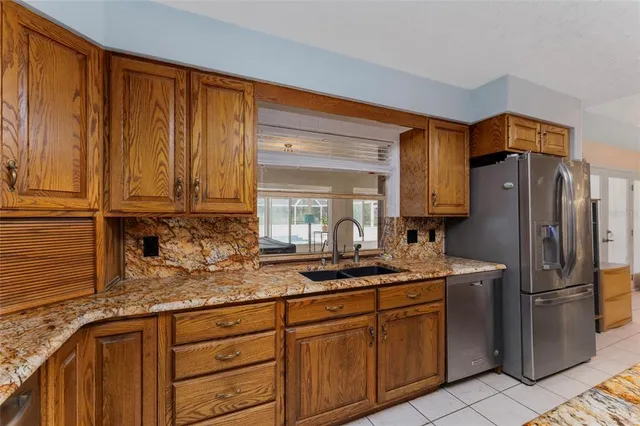 a kitchen with stainless steel appliances granite countertop a refrigerator and cabinets
