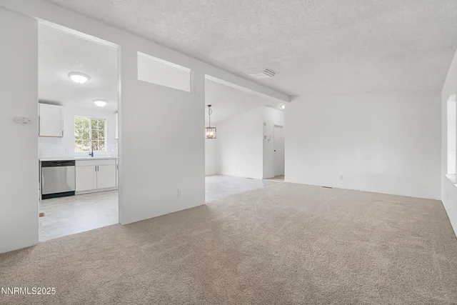 a view of an empty room with a kitchen