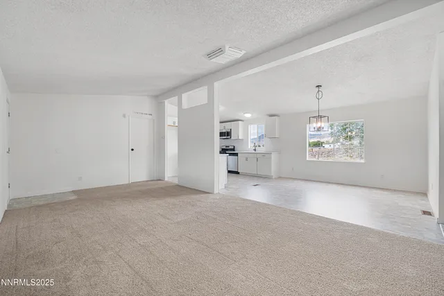 a view of a big room with windows and chandelier