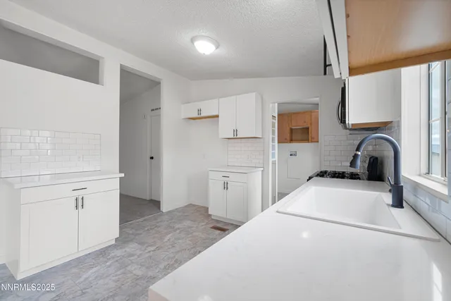 a kitchen with a refrigerator sink and white cabinets