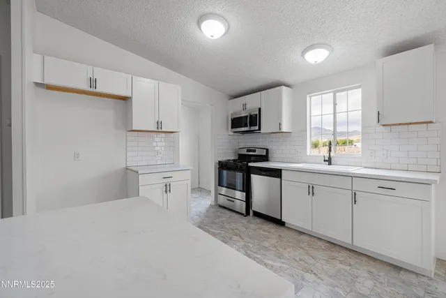 a kitchen with white cabinets and appliances