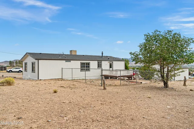 a white house that has a tree in front of it