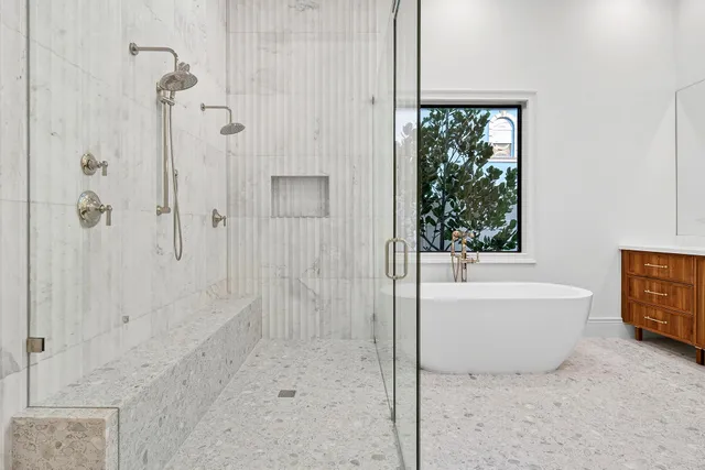 a bathroom with a bathtub a shower and a window