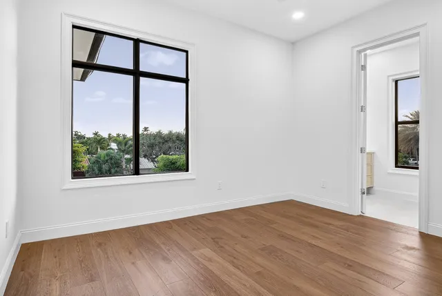 an empty room with a window and wooden floor