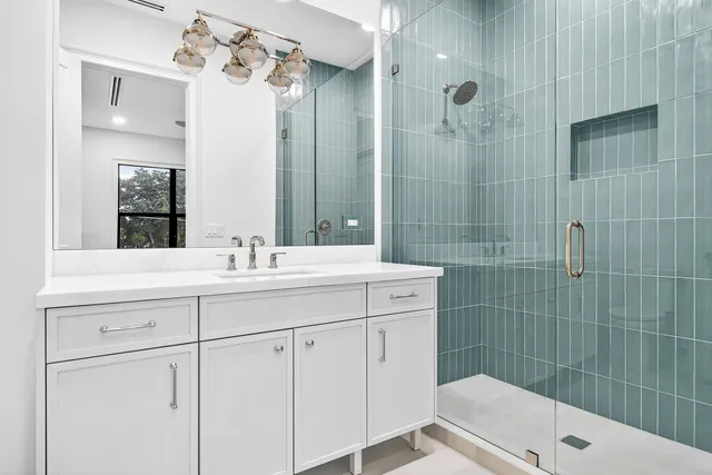 a bathroom with a sink a toilet a mirror and shower