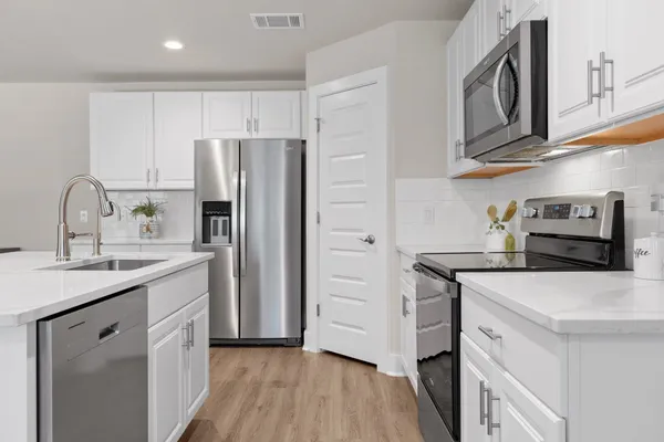 a kitchen with appliances a sink and cabinets