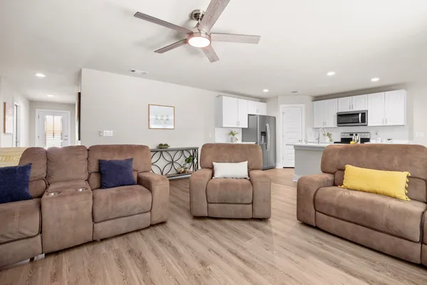a living room with furniture and a view of kitchen