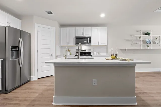 a kitchen with stainless steel appliances a refrigerator sink and cabinets
